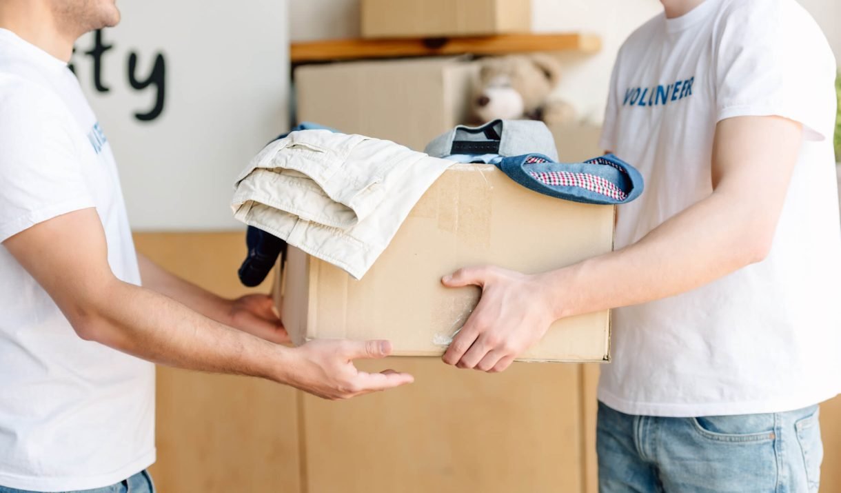 Cropped View Of Volunteers Holding Cardboard Box W K26FGND 1220x715