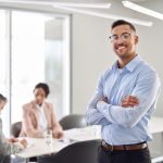 How to Choose the Right Strategic Consultant for Your Business smiling young latin business man manager standing at office meeting. portrait